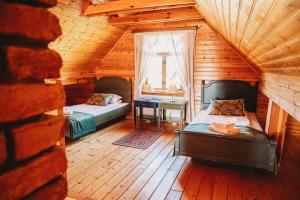 Stare MiastoSkansen Bicz Resort的小屋内设有一间带两张床和一张书桌的卧室