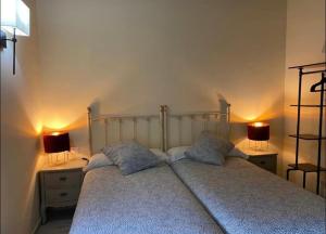 Valdaliga BUNGALOW LA COCINA的一间卧室,两边都配有一张床和两盏灯