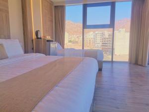 亚喀巴ALENA HOTEL的酒店客房设有两张床和大窗户。