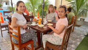 曼克拉Hospedaje Ola Marina的坐在餐厅桌子上的三个女孩