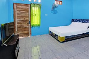 普拉亚SPOT ON 91811 Rumah Inap Bunda Nurhayati的蓝色的房间,配有床和电视