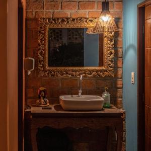 卡鲁阿鲁JasmiManga Pousada的浴室设有水槽和砖墙上的镜子