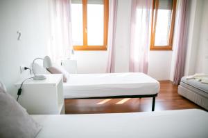 米兰米兰最佳住宿加早餐旅馆的白色的客房设有两张床和两个窗户。