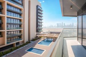阿布扎比Beautiful 1 Bedroom at Soho Square at Al Saadiyat Island的阳台享有带2个游泳池的建筑的景致。