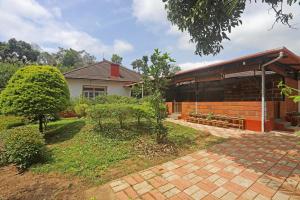 KuttaDevi Villa - Plantation Retreat and Forest Getaway的前面有花园的房子