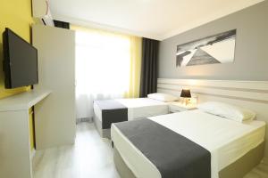 埃迪尔内Kaleroom EDİRNE的酒店客房设有两张床和一台平面电视。