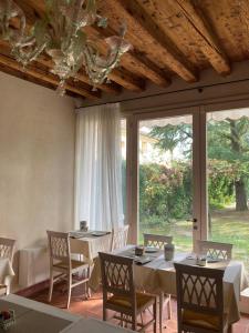 维琴察Agriturismo San Michele的一间带桌椅的用餐室和大窗户
