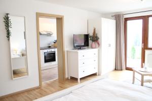 施卢赫湖Ferienhaus Carl的一间白色卧室,配有电视和镜子