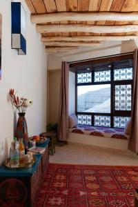 Zawyat OulmziTouda Ecolodge Atlas Mountains的客厅设有大窗户和桌子