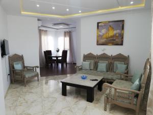 莫纳斯提尔Residence Debbabi的客厅配有沙发、椅子和桌子