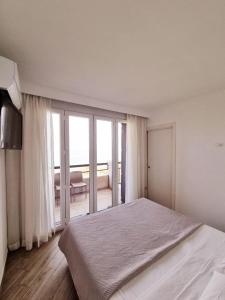 西尔米奥奈Appartamento ORCHIDEA a Sirmione sul Lago di Garda con piscina, giardino e spiaggia con molo的白色卧室设有一张大床和一个阳台