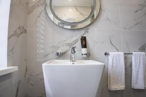 阿拉木图Resident Hotel Kazybek Bi的白色的浴室设有水槽和镜子