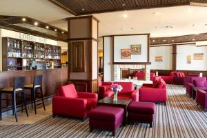 班斯科Luxory aparthotel in 4 star SPA hotel st Ivan Rilski, Bansko的一间设有红色椅子的餐厅和一间酒吧