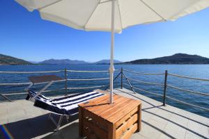 梅纳Resort Antico Verbano的船上甲板上的椅子和遮阳伞