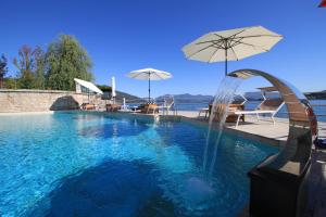 梅纳Resort Antico Verbano的一个带遮阳伞的游泳池