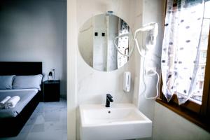 米兰米兰最佳住宿加早餐旅馆的一间带水槽和镜子的浴室以及一张床
