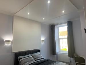 格拉斯哥Ibrox Argyll Sky Suite的一间卧室配有一张带镜子的床和窗户