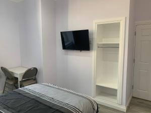 格拉斯哥Ibrox Argyll Sky Suite的一间设有床铺和墙上电视的房间