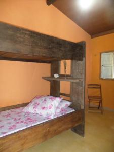 巴伊亚福尔莫萨Casinhas Vila Bonita Azul的一间卧室配有一张木制双层床和一把椅子
