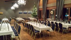凯乌鲁Hotelli Viikinhovi的宴会厅配有白色的桌椅和吊灯