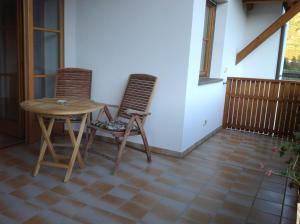 博尔扎诺Bbmarlene的带阳台的客房配有桌子和两把椅子