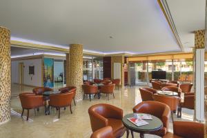 安塔利亚扎尔酒店的一间设有桌椅和电视的等候室