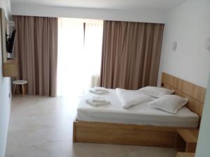 萨拉他蒙蒂鲁Pensiunea Duet的一间卧室配有带白色床单和枕头的床。