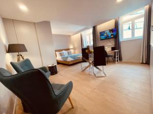 丰沙尔Living Funchal Executive的客厅配有两把椅子、一张床和一张沙发