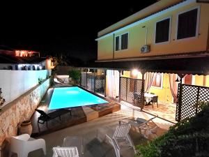 阿沃拉villa xenia的一座晚上设有游泳池的房子
