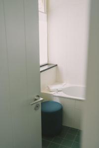 康布里特三男别墅酒店的一间带蓝色凳子和卫生间的浴室