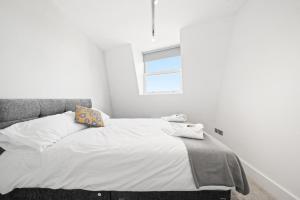 伦敦Manhattan-style 2bed near Camden Free WiFi的卧室配有带白色墙壁和窗户的床