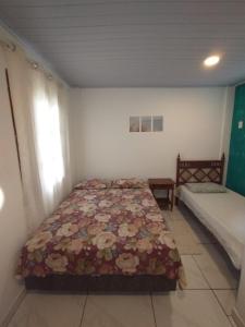 卡波布里奥Suites para casais na praça Oswaldo Cruz的卧室配有床和床,铺有四柱床。