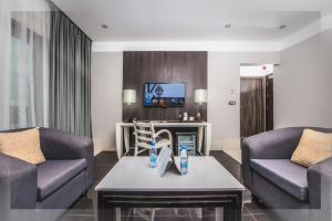 杜阿拉Krystal Palace Douala的客厅配有两张沙发和一台电视机