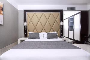杜阿拉Krystal Palace Douala的一间卧室配有一张大床和大床头板