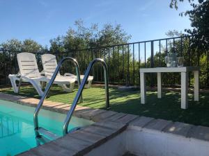 阿尔莫多瓦尔德尔里奥Casa del Almezo的游泳池旁的一对椅子和一张桌子