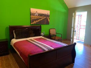 瓜达鲁佩镇Posada Del Valle的一间拥有绿色墙壁的卧室和一张位于客房内的床
