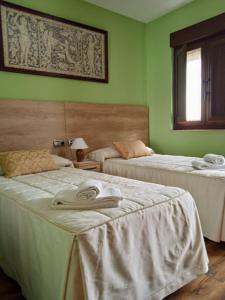 莫加拉斯Casa Rural Buenavista的绿墙客房内的两张床
