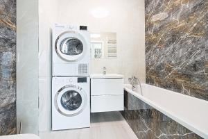 埃尔布隆格Varsovia Residence apartament 17 Parking的浴室设有洗衣机和烘干机,毗邻水槽