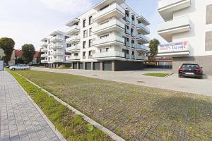 埃尔布隆格Varsovia Residence apartament 17 Parking的大型公寓大楼前的停车位