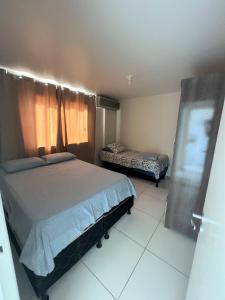 萨尔瓦多Sol de Bora Bora 101的一间卧室设有一张大床、一张床和一个窗户。