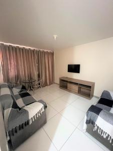 萨尔瓦多Sol de Bora Bora 103的一间卧室配有两张床和一台平面电视