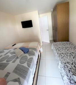 萨尔瓦多Sol de Bora Bora 103的一间卧室配有两张床和一台平面电视