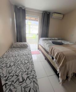 萨尔瓦多Sol de Bora Bora 103的一间卧室设有两张床和窗户。