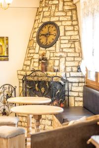 卡拉维塔安纳斯琼酒店的石墙上大钟,有两张桌子