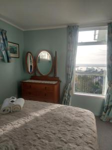 奥玛鲁奥马鲁绿色度假屋的一间卧室配有一张床、镜子和窗户