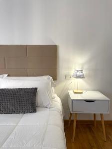 佩鲁贾Filo Guest House的卧室配有白色的床和带台灯的床头柜。