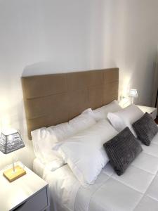 佩鲁贾Filo Guest House的白色的床、白色枕头和棕色床头板