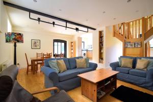 莱姆里吉斯Yard Cottage的客厅配有蓝色的沙发和桌子