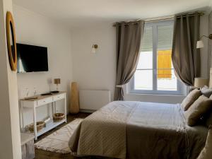 丰特夫罗拉拜Fontevraud Les Chambres的白色的卧室设有床和窗户