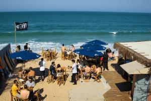 弗洛里亚诺波利斯Graffi Beach House的一群人坐在海滩上,拿着蓝伞